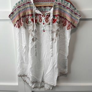 White Johnny Was shortsleeved blouse with brightly-colored embroidery.